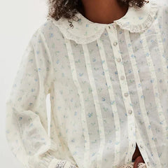 Printed long sleeve blouse styled casually with jeans for a relaxed, vintage-inspired daytime look.