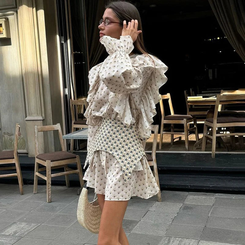 Woman in side view of patterned waist seal cinching a printed summer mini dress with tables and chairs in the background