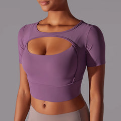 Purple mesh keyhole yoga crop top worn by a woman for gym or running by a person on a grey background