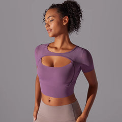 Quick dry purple active short sleeve crop styled for yoga and sport, worn by a woman  against a gray background
