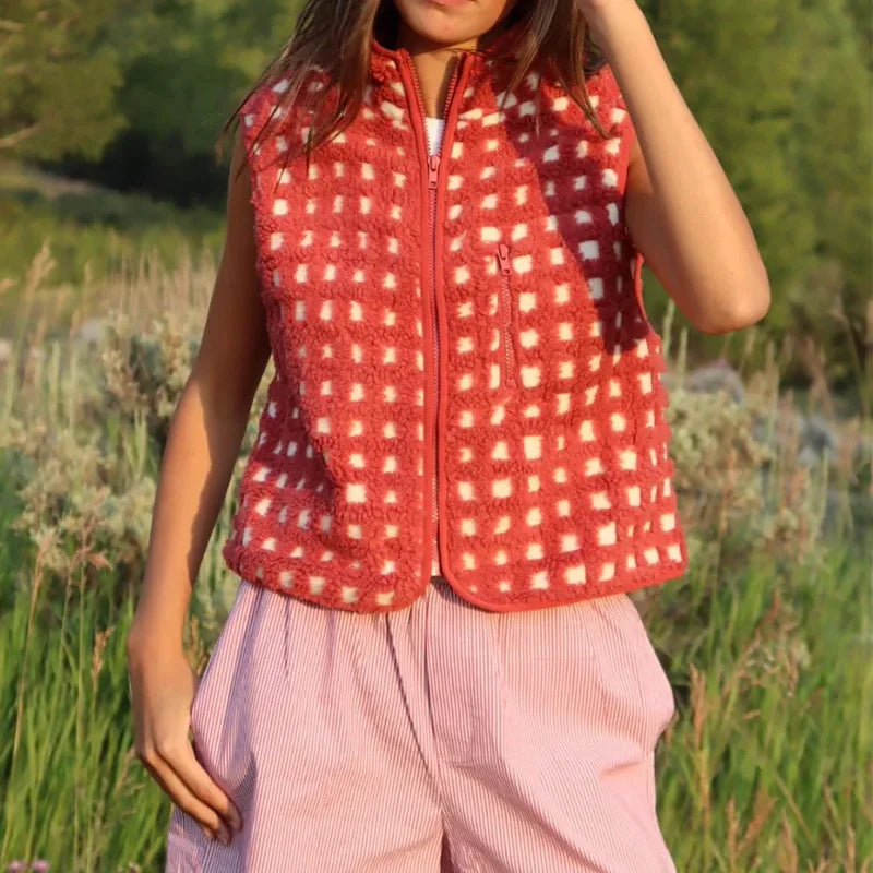 Person wearing a red checkered vest in a natural setting