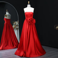 Red strapless satin A-line evening gown with rosette waist detail on mannequin