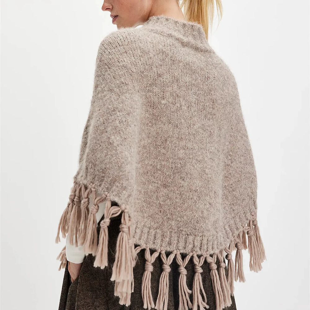 Angled view showing the relaxed drape and open poncho silhouette as it falls naturally over the body.