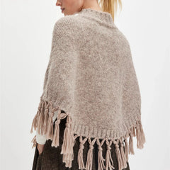 Angled view showing the relaxed drape and open poncho silhouette as it falls naturally over the body.