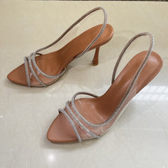 Rhinestone sling back heels featuring crystal-clear PVC straps and a shimmering rhinestone trim.