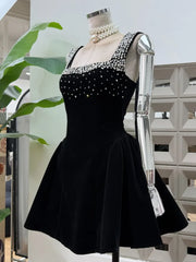 Close-up of the square neckline showing rhinestone and pearl-look embellishment on a velvet-look mini dress displayed on a mannequin.