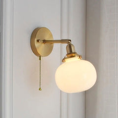 A Lighted close-up of the ribbed clear glass globe on a Nordic-style sconce.