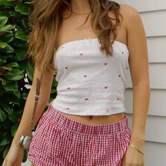 A woman modeling a ribbed tube top with lace trim in a Y2K-inspired style.