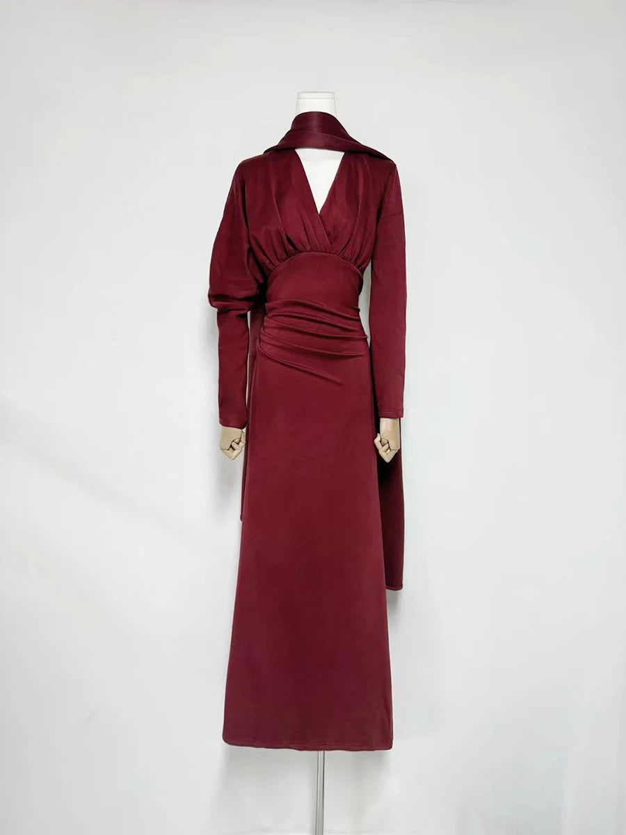 Side profile of a satin maxi dress with draped waist and long sleeves.