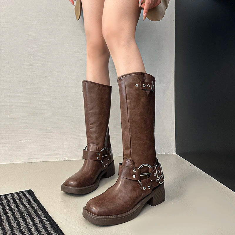 Rivet accent plush-lined midcalf boots for autumn urban wear, worn by a person on a neutral background.