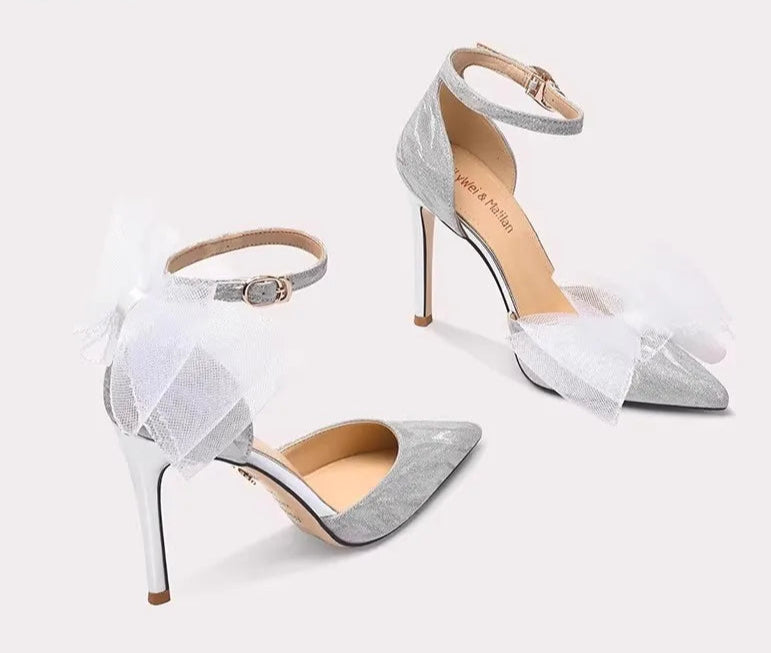 Pair of high-heeled shoes with sheer overlay on a white background