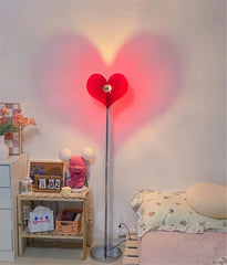 Romantic heart floor lamp casting red shadow in a cozy bedroom