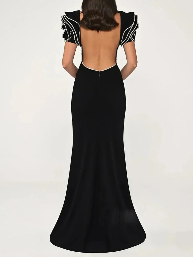 Back view of the black maxi dress capturing the natural drape and clean zipper closure.
