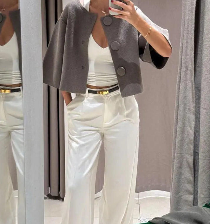 Outfit-focused shot featuring a gray button-detail knit cardigan with a rounded neckline, styled sleekly for a modern, minimal look.