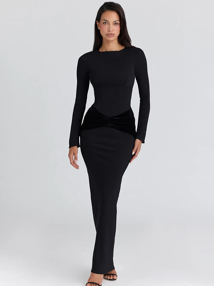 Editorial full-length studio view of a long-sleeve ruched maxi dress with A-line drape and confident evening posture.