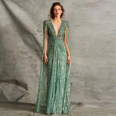 A woman wearing a sage green A-line gown with a V-neckline.