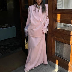 A woman modeling a satin blazer and long skirt two-piece set.