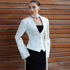 A woman wearing a slim-fit blazer with a scarf ribbon, styled for a chic look.
