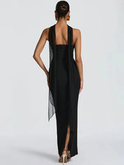 Woman wearing a black dress with a sheer overlay on a white background
