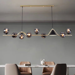 Sculptural bar chandelier with globes above a contemporary dining table