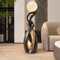 Sculptural black and gold floor lamp in a modern foyer