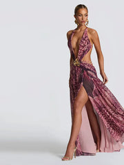 Woman wearing a halter maxi dress with seashell buckle and waist cutouts on a white background