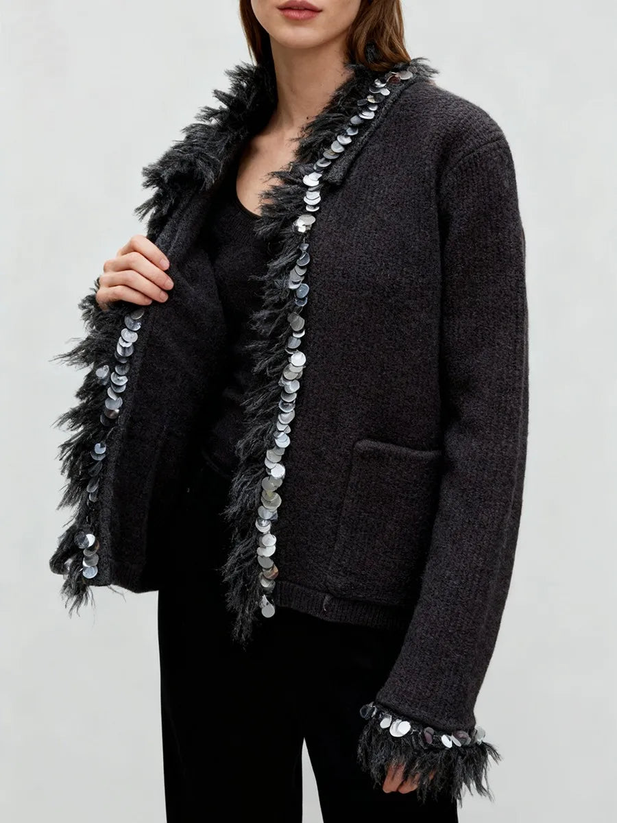 Side angle of a casual knit jacket with relaxed sleeves and decorative trim for everyday layering.