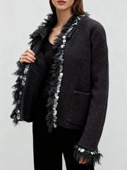 Side angle of a casual knit jacket with relaxed sleeves and decorative trim for everyday layering.