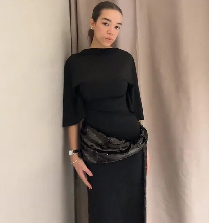 Close-up of the black dress waist with sequin embellishment, showing texture and detailing.