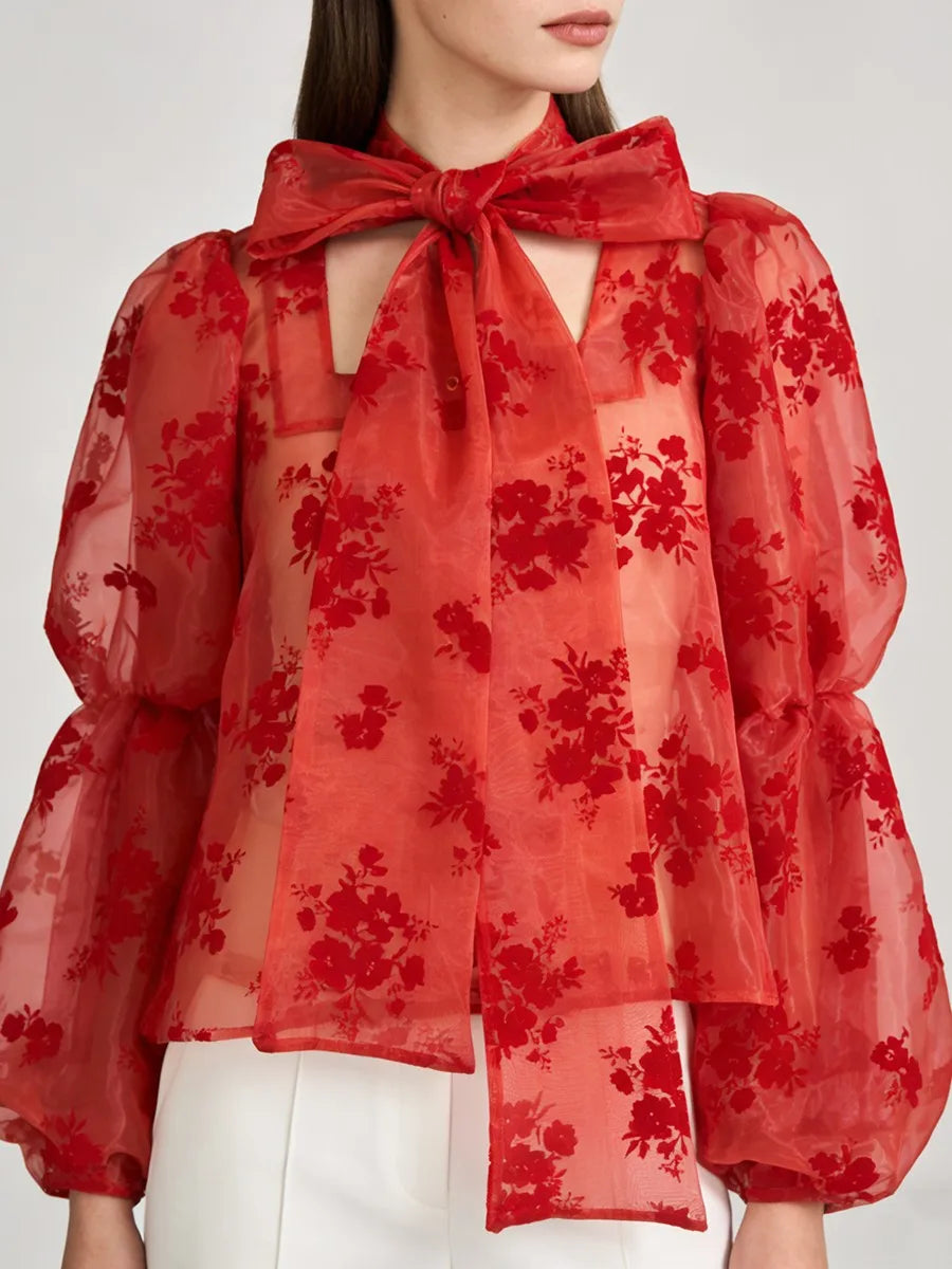 Close-up of bow-neck detail and lightweight sheer woven texture on expressive blouse