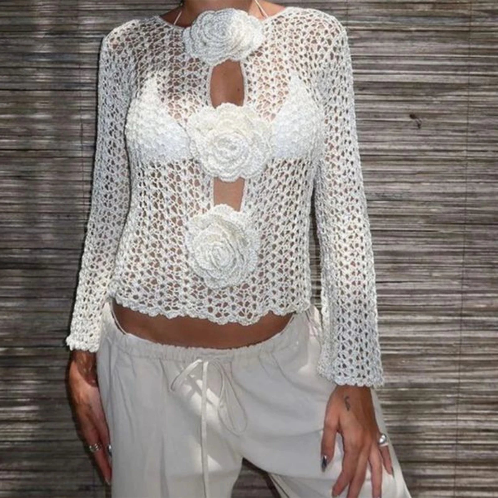 A close-up of the sheer knitted top, showing the intricate hollow-out and applique details.