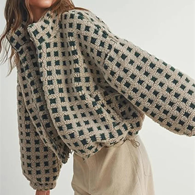 Person wearing a patterned sweater with a neutral background