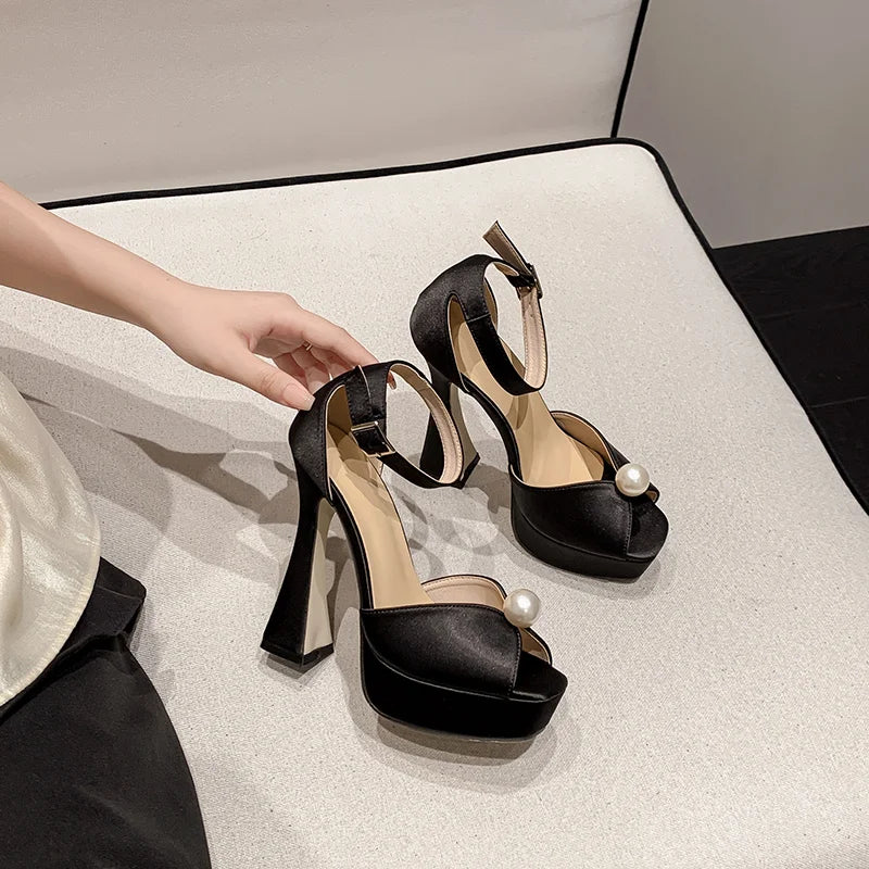 Silk upper high heel wedding shoe with pearl detail, styled for parties  on a light surface.