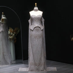 A woman modeling a silver crystal evening gown with a sweetheart off-shoulder neckline.