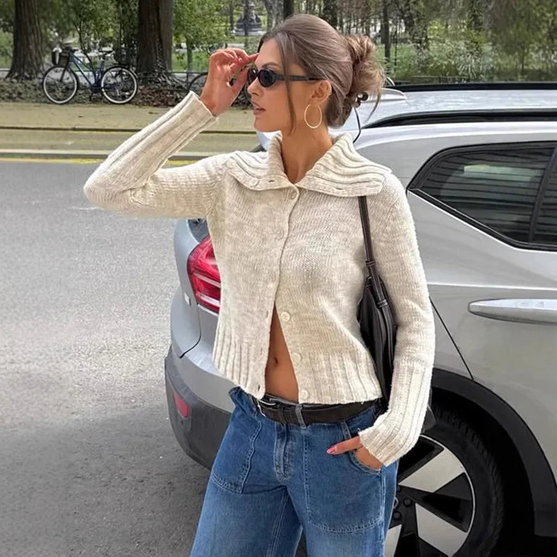 A woman wearing a single-breasted lapel cardigan in a sleek, commuter style.

