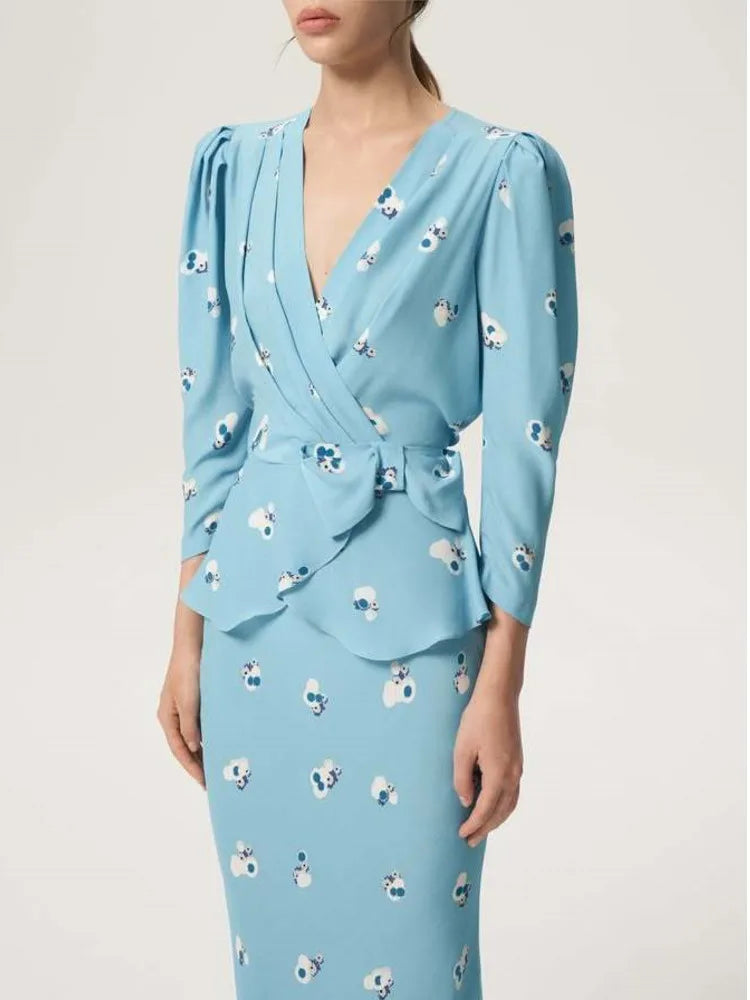 model in a sky blue floral wrap top with matching pencil skirt
