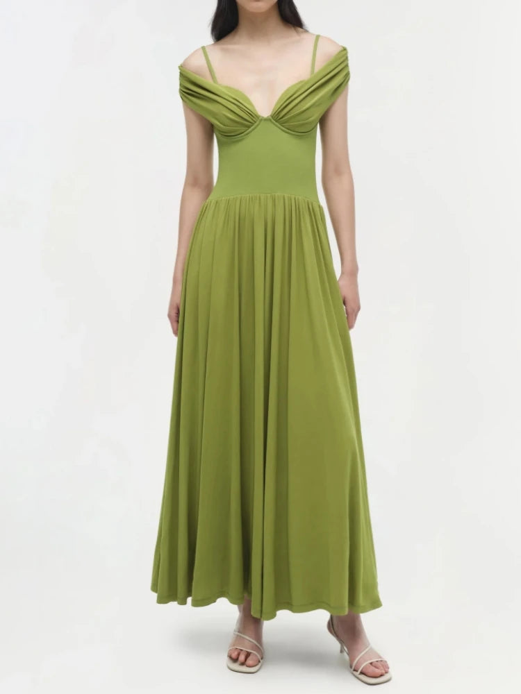 Slash neck green evening dress with slim straps and ankle-length cut worn by a model on a white background