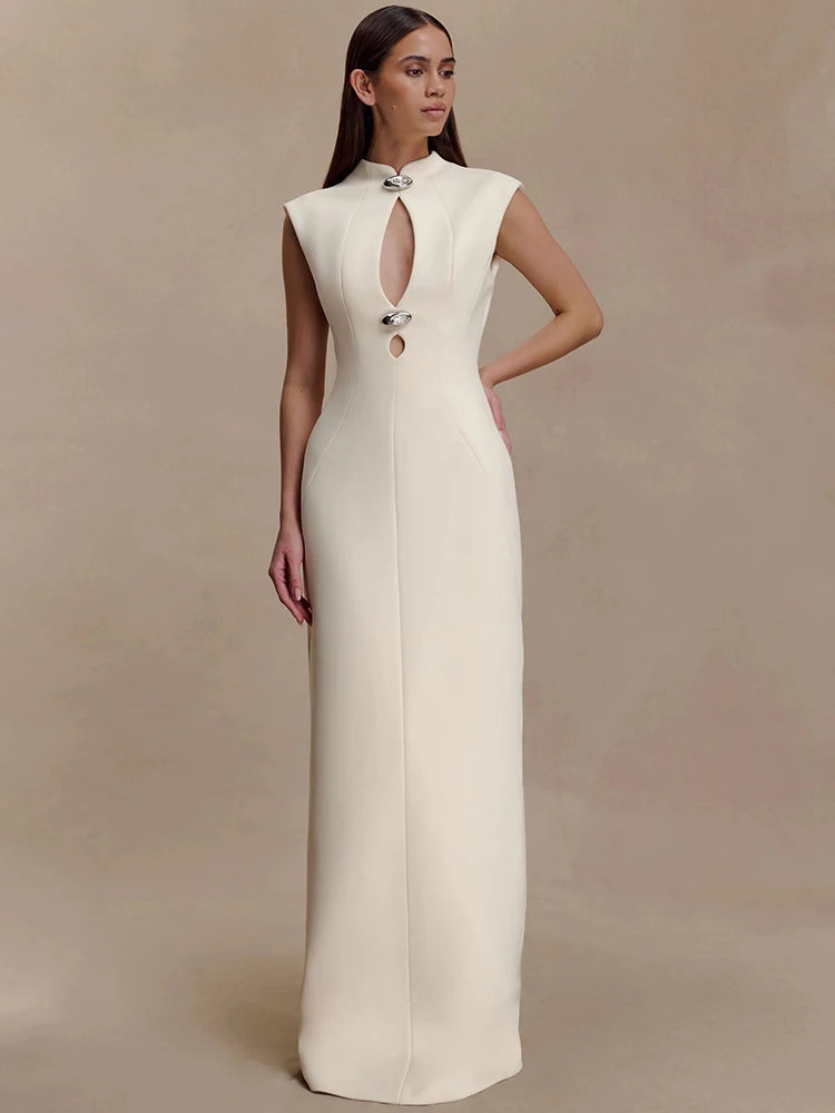 Full-length view of the sculptural neckline and smooth floor-length drape, styled against a soft neutral background.