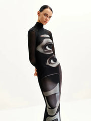 Model wearing a ankle length black sheath dress with surreal print design on a white background