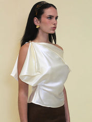 The slim silhouette of the short-sleeve satin blouse on a model.