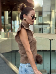 Side angle showing the slim fit and clean lines of the sleeveless knit top worn in an outdoor setting.