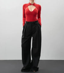 Person wearing a red top and black pants on a plain background