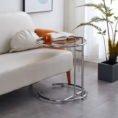 Compact C-frame side table positioned next to an armchair