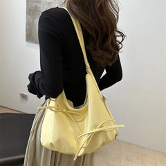Soft yellow shoulder bag with bow details on surface