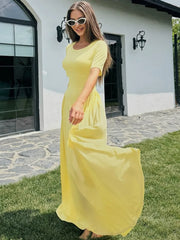 A woman in a casual, solid colour short-sleeve dress for everyday wear, standing outdoors on a patio.