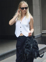 Solid color V-neck knit top styled with trousers