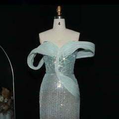 Teal evening gown with intricate design on a mannequin against a black background