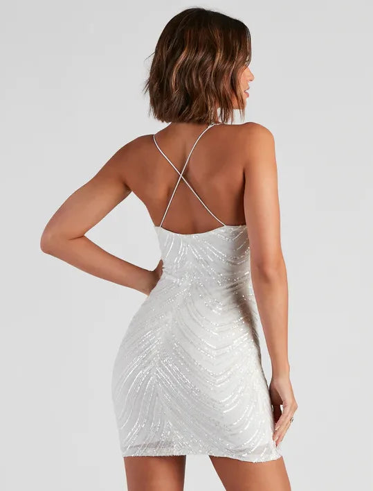 Woman wearing a  sparkling V-neck above-knee dress designed for cocktail gatherings with a backless design on a plain background