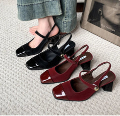 Black and red square toe high heel sandals on textured carpet