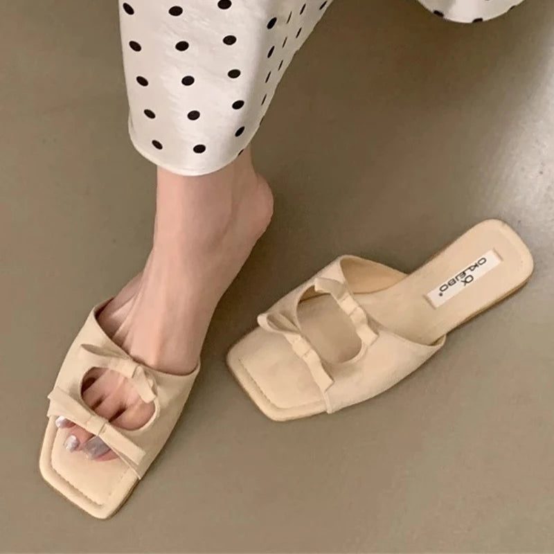  Square-toe fashion flip flops with plush bow accent, shown for summer beige sandals worn with polka dot pants on a neutral background